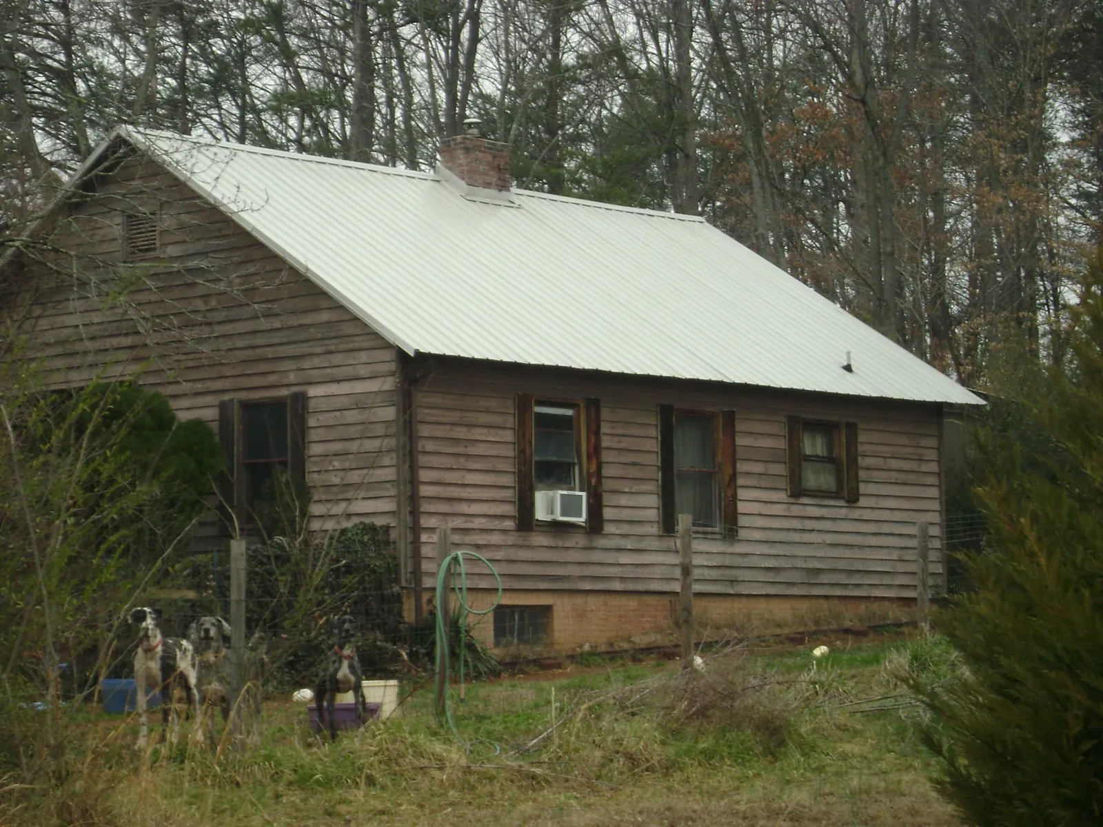 White metal roof on an old wood sided farmhouse, from a Metal Roof Installation job in Warners